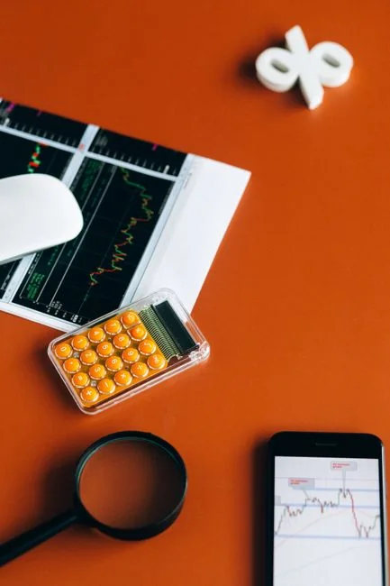 Focused image of hands analyzing business graphs and charts in a folder, highlighting data insights.